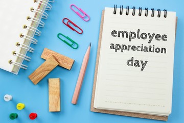 Text Employee appreciation day on white paper book and office supplies on blue desk / business concept