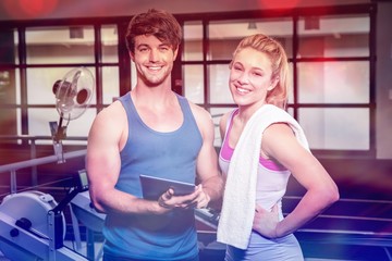 Portrait of trainer and woman standing with digital tablet