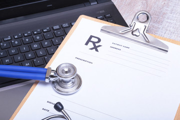 Prescription form with laptop computer and stethoscope