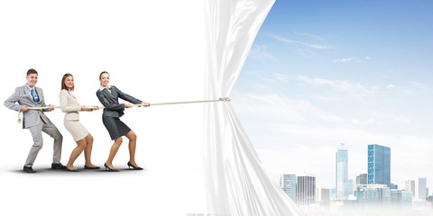 Young businesspeople working in collaboration and pulling white advertisement banner