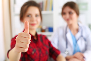 Smiling female patient showing thumb up