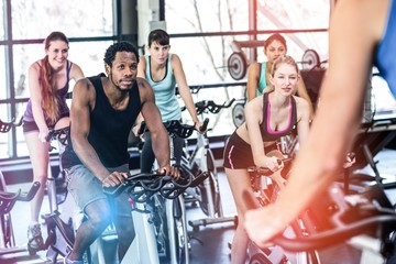 Fit people working out at spinning class - obrazy, fototapety, plakaty