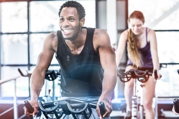 Fit man working out at spinning class