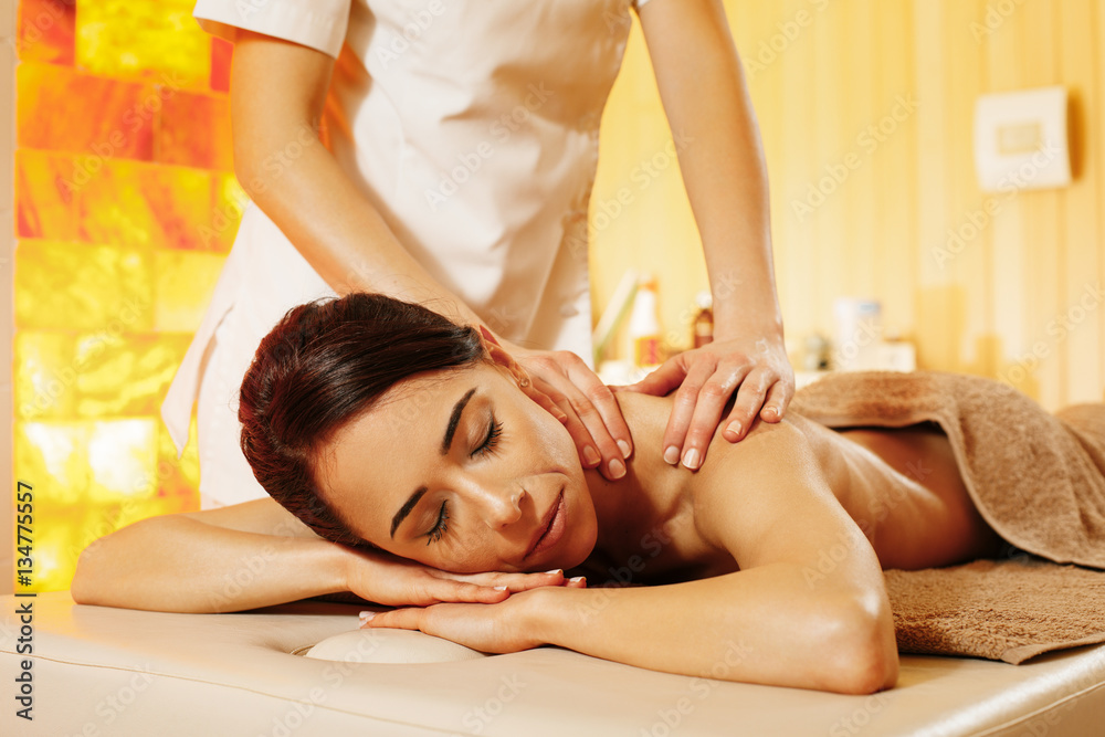 Wall mural woman having massage in the spa salon