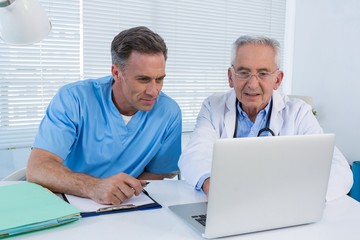 Fototapeta premium Surgeon and doctor discussing over laptop