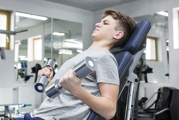 Fototapeta premium Teenage boy engaged in the gym hall