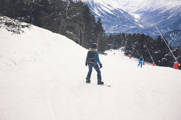 Fototapeta na wymiar Woman snowboarder on the slopes of the resort on a winter day.
