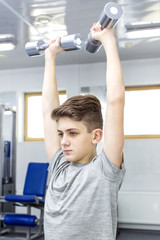 Fototapeta na wymiar Teenage boy engaged in the gym hall