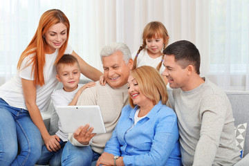 Happy family with tablet on couch