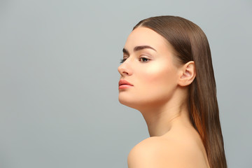 Portrait of beautiful young woman on grey background