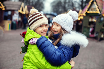 Fototapeta premium Children boy and girl met in the city, hugging and rejoicing. 