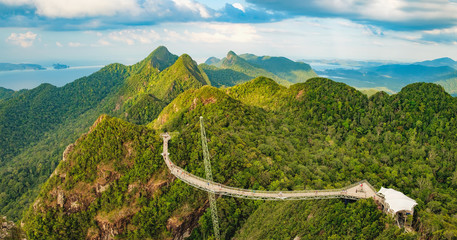 Panoramic view of Sky Bridge and Cable Car with mountains, sea and tropical forests in the background, Langkawi island, Malaysia. Langkawi SkyCab is one of the major attractions in the island - obrazy, fototapety, plakaty