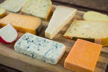 Variety of cheese on wooden board