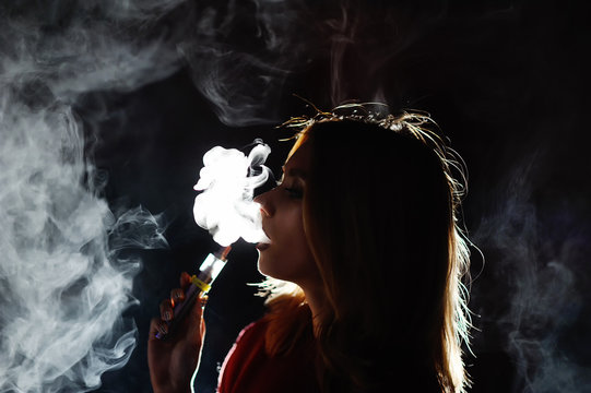 pretty girl viper smoke e-cigarette in a nightclub