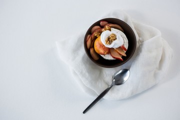 Brie cheese served with fruit slices and walnut in a bowl