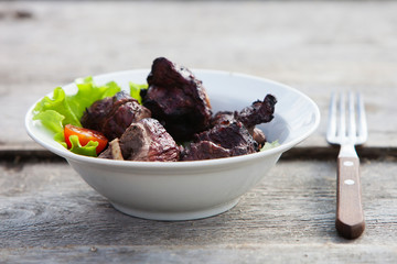 Grilled shashlik on white plate on wooden table