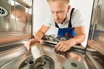 Man In Overall Repairing Dishwasher