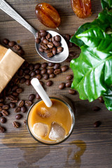 Fototapeta premium coffee with ice in glass on wooden background top view