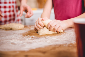 Little girl kneading pizza dough
