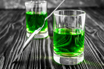 absinthe with sugar cubes and spoon on wooden background