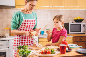 Mother and daughter preparing pizza