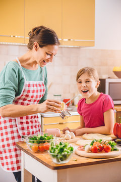 Mother and daughter preparing pizza