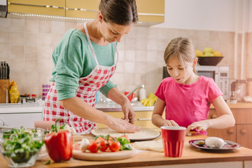 Mother and daughter preparing pizza