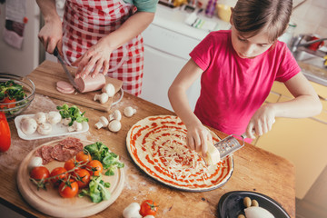 Mother and daughter preparing pizza