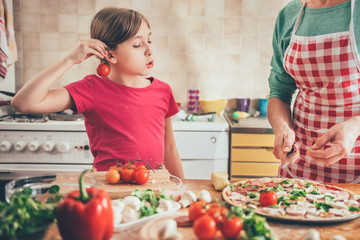 Mother and daughter preparing pizza