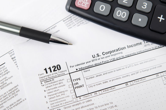 US tax form 1120 with pen and calculator