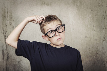 Boy scratching his head.