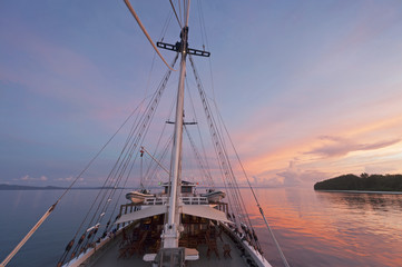 Fototapeta na wymiar Schooner Sailboat Travel in Raja Ampat. There are around 1,500 uninhabited and remote islands in the Raja Ampat area of eastern Indonesia. Travel by boat is the only way to explore this region.