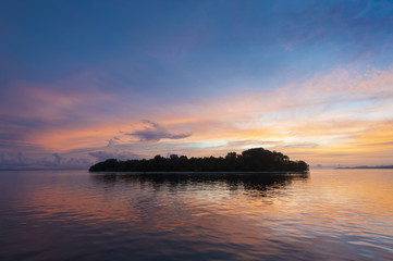 Raja Ampat Island at Sunset. There are around 1,500 uninhabited and remote islands in the Raja Ampat area of eastern Indonesia. This one is featured during a glorious sunset.