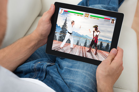Man Playing Videogame On Digital Tablet