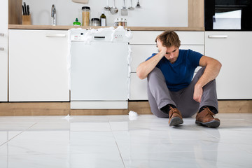 Man Sitting Next To Dishwasher