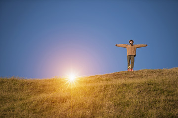 Maori woman standing alone in the sheep field in cleared sky, new zealand