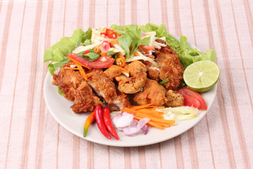 Spicy deep-fried chicken salad with roll green mango .