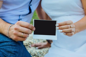Couple holding photo instant in hands.