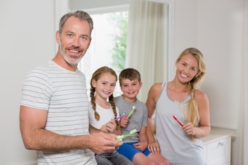 Portrait of parents and kids brushing teeth in bathroom
