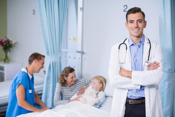 Obraz premium Portrait of smiling doctor standing with arms crossed
