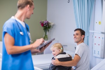 Doctor using digital tablet while talking to patient