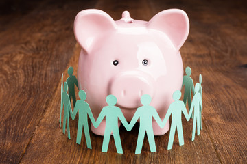 Papercut With Piggybank On Wooden Desk