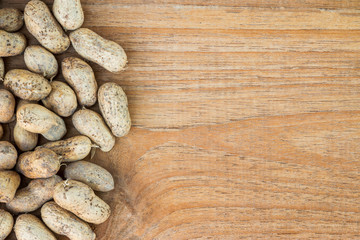Raw peanuts in shell on wooden background or texture. close up p