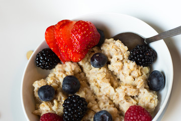 Oatmeal in a bowl, deep plate with berry, berries. Rassberry, blueberry, blackberry and strawberry. Healthy breakfast