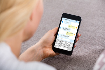 Woman Sending Text Message Using Mobile Phone