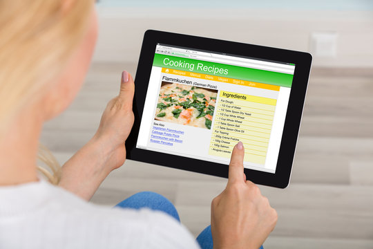 Woman Using Digital Tablet For Learning Recipe