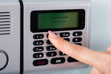 Person Hand Using Home Security Alarm