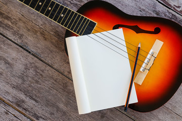 Ukulele and Paper Notes on Wooden background