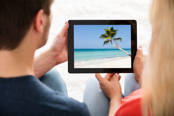 Couple Looking At Photo On Digital Tablet
