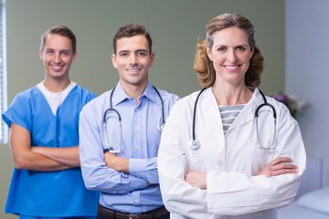 Portrait of smiling doctors standing with arms crossed